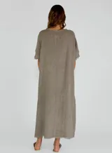 Vestido midi de lino en color beige, con diseño holgado, cuello redondo y detalles de costuras con terminaciones desflecadas en el frente y las mangas.
