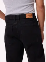 Jean de corte slouchy fit, confeccionado en denim de algodón color azul medio. Presenta diseño de cinco bolsillos, cierre frontal con botón y costuras reforzadas en tono contrastante.