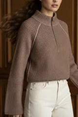 Sweater marrón de punto acanalado, con cuello alto, cierre frontal parcial con cremallera y manga larga.