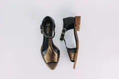 Sandalias de cuero con taco bajo de madera, color negro y dorado.