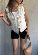 Chaleco blanco con bordado de flores color beige, con escote en V y cierre frontal con lazos.