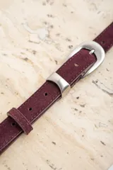 Cinto de cuero negro con textura de gamuza, presenta una hebilla metálica plateada de diseño clásico y puntera metálica a juego.