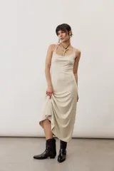 Vestido largo color verde suave, sin mangas, con escote redondo y silueta al cuerpo que se ensancha levemente hacia el dobladillo.