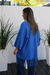 Saco abierto de punto color azul vibrante, con mangas tres cuartos y detalle de flecos largos en el ruedo.