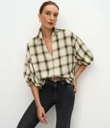 Blusa de viscosa con estampado de cuadros en tonos beige y verde. Presenta cuello en V, cierre frontal con botones y mangas 3/4 abullonadas con puños elásticos.