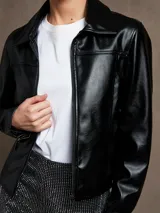 Campera negra de cuero sintético, corte entallado, con cierre frontal y cuello clásico.