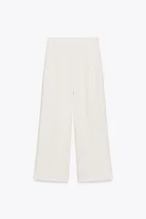 Pantalón tipo culotte de tiro alto, pierna ancha y pinzas frontales. Color beige/topo liso.