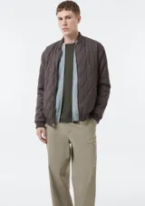 Campera bomber reversible, de diseño acolchado con costuras romboidales, cierre frontal completo y bolsillos laterales.