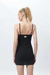 Vestido corto negro, ajustado al cuerpo, sin mangas y con escote cuadrado. La tela presenta una textura tramada o con relieve.