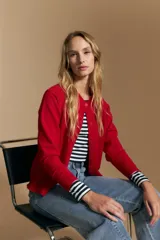 Cardigan de tejido de punto color rojo, con cuello redondo, cierre frontal de botones al tono y puños acanalados.
