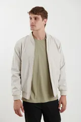 Campera tipo bomber color natural con cierre frontal y cuello, puños y cintura acanalados.