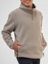 Buzo de polar color beige con cuello alto y cierre frontal parcial. Cuenta con bolsillos laterales con cierre y tiradores de cuero.