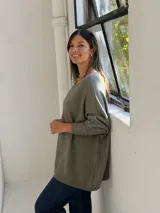 Sweater de tejido de punto en color verde seco, con cuello redondo, corte holgado y mangas largas con puños acanalados.