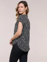 Camisa de manga corta con estampado animal print, cuello con solapa, escote en V y cierre frontal con botones.