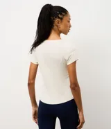 Remera deportiva de manga corta y cuello redondo, confeccionada en tejido crepe de poliamida. Presenta un diseño liso en color blanco con estampa frontal con la palabra 'Practice' en efecto gel.