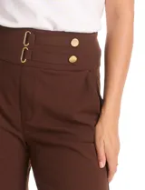Pantalón de vestir color marrón, de corte wide leg y tiro alto. Presenta una cintura ancha con detalles de hebillas y botones decorativos en tono dorado, además de bolsillos laterales funcionales.