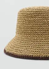Sombrero tipo bucket de fibra natural trenzada en color tostado, con detalle de borde marrón oscuro.
