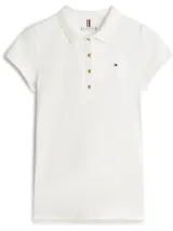 Chomba de piqué blanca de corte slim, con cuello polo, cartera de cuatro botones y mangas cortas abullonadas. Presenta el logo de la marca bordado en el pecho.