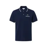 Remera polo Lacoste de manga corta en color azul marino, con detalles en blanco en el cuello y en los bordes de las mangas. Cuenta con un bolsillo frontal en el pecho adornado con ribete blanco y el clásico logotipo del cocodrilo bordado, además de cierre frontal con botones.