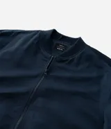 Campera bomber negra para hombre, confeccionada en poliéster con cierre frontal de cremallera, cuello, puños y dobladillo elásticos acanalados, y bolsillos laterales.