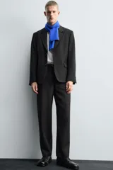 Pantalón de traje corte straight fit confeccionado en tejido mezcla de lana. Presenta cierre frontal con cremallera y botón, bolsillos laterales y bolsillos traseros de vivo.