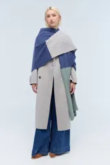 Ruana tejida de punto con bloques de color azul, gris y verde. Confeccionada en lambswool.