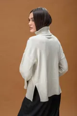 Sweater de punto color azul marino con cuello alto y diseño holgado. Presenta mangas con hombros caídos, terminaciones acanaladas y apliques de líneas orgánicas en relieve de color blanco que forman figuras florales en el frente y las mangas.