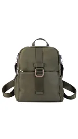 Mochila de tamaño mediano, color beige claro, con cuerpo principal de tela impermeable y detalles en simil cuero liso en la parte inferior y correas. Presenta un asa superior corta y correas ajustables para llevar al hombro o cruzada. Cuenta con un bolsillo frontal con cierre y un detalle decorativo de correa con hebilla metálica rectangular.