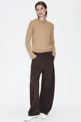 Pantalón de tiro alto con diseño tipo balloon, cintura con trabillas, bolsillos laterales y cierre frontal con cremallera y botón.