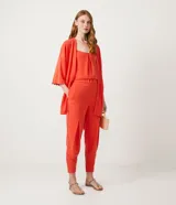 Pantalón jogger color naranja, con cintura elástica, hebilla y bolsillos laterales.