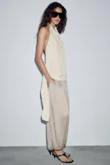Pantalón de tiro medio con cintura elástica y bajo acabado en puño elástico. Presenta un diseño con tejido efecto arrugado y bolsillos laterales ocultos en costura.