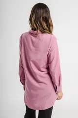 Camisa blanca de corte clásico, con cuello abotonado, manga larga y bolsillo en el pecho.