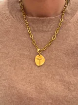 Collar de cadena de eslabones gruesos con baño de oro, que presenta un dije circular con una cruz en relieve.