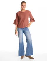 Buzo tejido de punto fino color blanco, con cuello redondo y mangas tres cuartos con terminación acampanada.