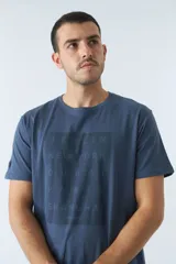 Remera azul de algodón con cuello redondo y estampado frontal con nombres de ciudades: Berlín, Nueva York, Dubai, París y Shanghái.