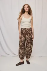 Pantalón de tiro alto y silueta amplia con estampado floral, pinzas en el frente, volumen relajado y terminación elastizada en los tobillos.