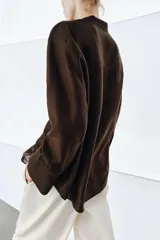 Camisa ZW Collection de color marrón oscuro, con cuello mao, manga larga con puños anchos y cierre frontal oculto por solapa. Cuenta con un bolsillo de parche en el pecho adornado con bordados a tono, los cuales también se repiten en los puños.