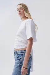 Remera blanca de algodón con cuello redondo y nudo ajustable en la espalda o el frente.