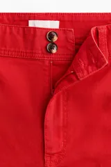 Pantalón en lona de algodón con cintura de tiro alto y cierre con botones. Piernas rectas con raya adelante y atrás, y bolsillos atrás de parche.