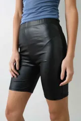 Calza biker de tiro alto confeccionada en tela engomada de acabado brillante y diseño ajustado.