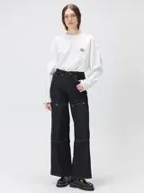 Pantalón de tiro medio y pierna ancha confeccionado en denim de algodón grueso. Presenta un diseño a rayas verticales en tonos azul y celeste, con costuras en contraste color rojo, bolsillos laterales tipo cargo y remaches metálicos.