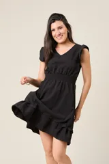 Vestido corto blanco con cuello en V, mangas cortas con volados, cintura elastizada y falda con volados.