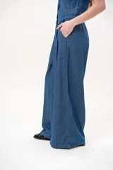 Pantalón azul de corte wide leg, con cintura elástica ajustable mediante cordón y bolsillos laterales.