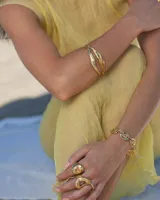 Anillo plateado con forma orgánica irregular y un agujero en el centro.