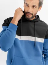 Canguro con capucha y cordones ajustables, de diseño tricolor con bloques en negro, gris y azul. Cuenta con bolsillo frontal tipo canguro y puños elásticos.