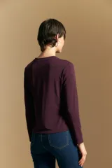 Remera de manga larga en color negro, con cuello redondo y costura vertical central en el frente. Presenta un diseño minimalista de calce ajustado y líneas limpias.