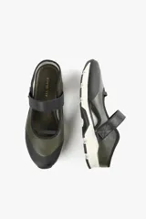 Zapato de diseño urbano color blanco con detalles en negro y amarillo, suela dentada y tira de velcro en el empeine.