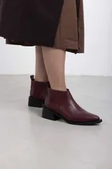 Botineta de cuero negro con textura sutil, con elásticos laterales y taco cuadrado bajo.