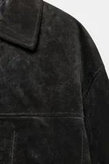 Cazadora oversize de piel de ante 100%, con cuello solapa, manga larga, bolsillos laterales de vivo y bolsillo de plastrón en el pecho. Cuenta con forro interior a tono y cierre frontal con botones.