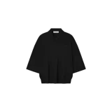 Remera polo de punto color negro, de corte holgado, mangas cortas y cierre frontal con botones. Presenta un pequeño logo bordado en el pecho.